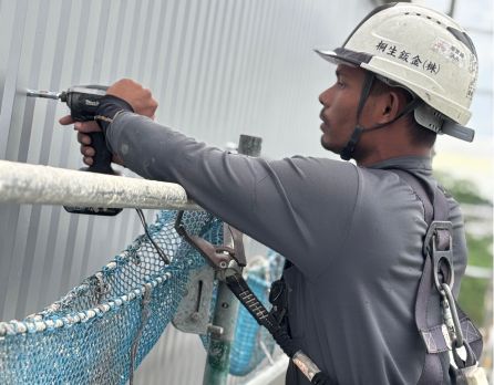 壁面に板金を取り付ける作業