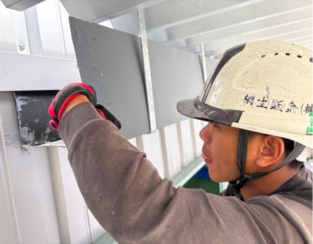 壁面に板金を取り付ける作業