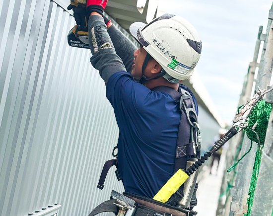 桐生鈑金の作業員が板金を取り付けている姿
